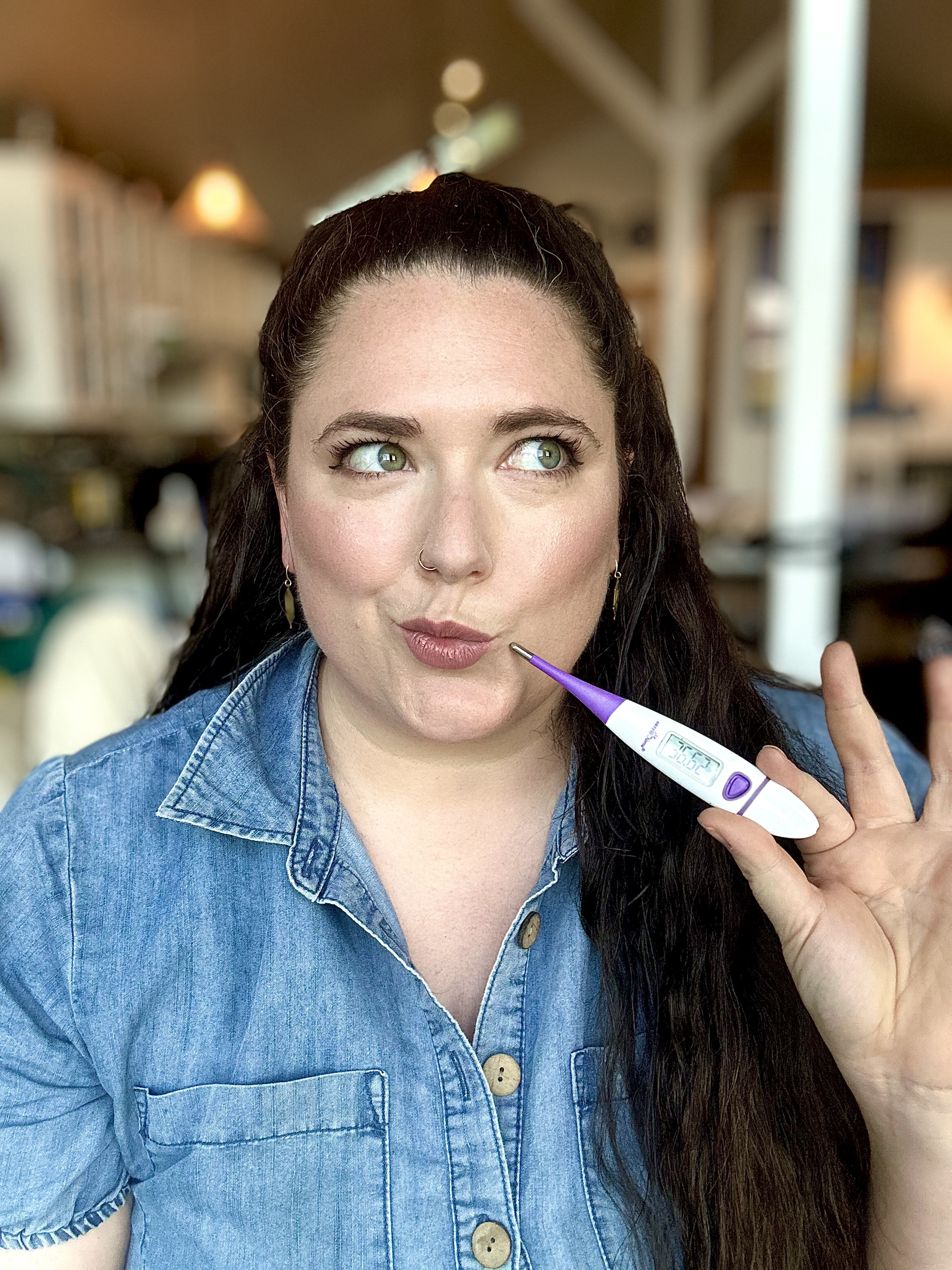 Sophie holding a basal body temperature thermometer